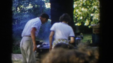 1954: a man looking over the grill cooking the food outside NEVADA