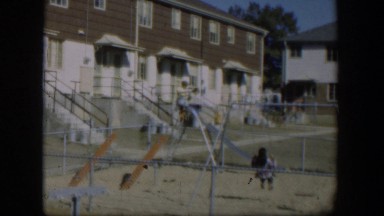 1954: two girls go down a slide while a third girl is on a swing