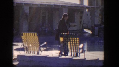 1954: Woman in a Coat Walking Along a Public Pool, Nevada