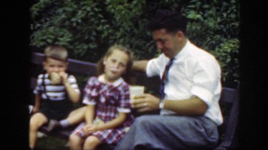 1948: dad with young girl and boy on a park bench eating and drinking WASHINGTON