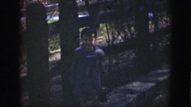 1949: Small Boy in Striped Jacket Standing by Picket Fence Before Running Away Cincinnati Ohio