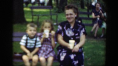 1948: woman and two children seated on a bench in a park like setting WASHINGTON