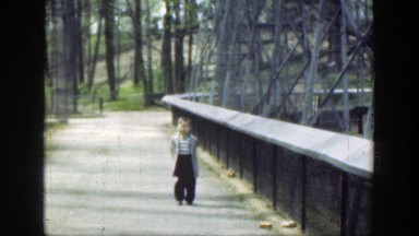 1949: Little Boy Walking Outside on a Bridge in Cincinnati Ohio