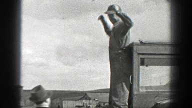 1937: Man in Overalls Taking Off Hat with Dog Walking California