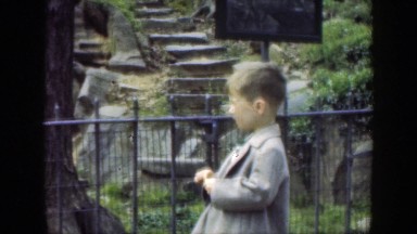 1949: cute child standing wearing jacket in a garden area CINCINNATTI OHIO