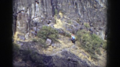 1937: Person Holding Blue Jacket Descends Rocky Trail