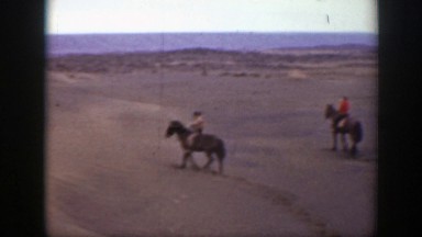 1939: three individuals horseback riding on desert terrain MONTANA