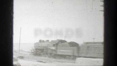 1939: passenger train passes through swiftly, with low hills in background