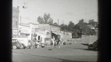 1939: two gentlemen riding their horses through town WYOMING