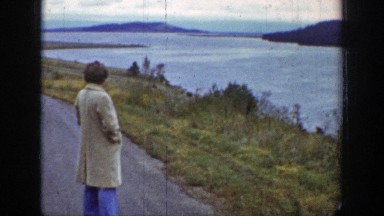 1939: A Person Wearing Long Coat Standing on Road Near River Wyoming