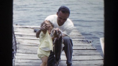 1953: Man and Kid Holding Fish on Rope Near Wisconsin Lake