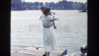 1953: Mom Picks Up Baby on Dock Wisconsin