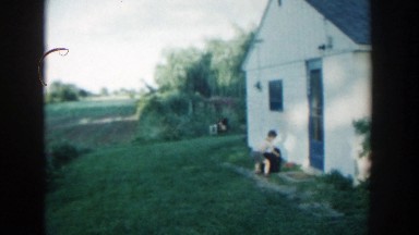 1957: little boy hiding by the edge of the house. MICHIGAN