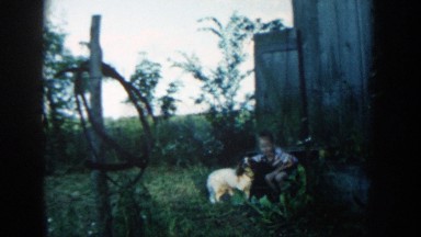 1957: a boy playing with his dog and smiling to the camera MICHIGAN