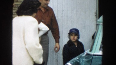1957: a cute white little boy meet a lady and scared when kiss her for welcome.