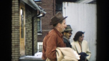 1957: random people standing around some buildings. MICHIGAN