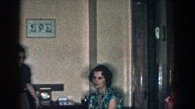 1957: a woman sitting in a green metal chair inside a house MICHIGAN