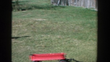 1958: small children playing with red wagons in the field. MICHIGAN