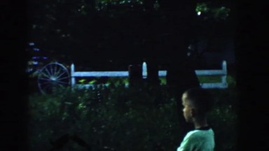 1957: a young boy chasing his dog through the yard while his mom watches