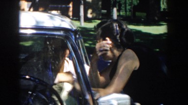 1958: woman talking to a man inside a car. MICHIGAN