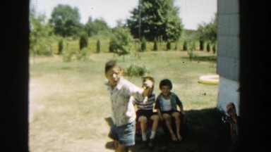 1958: children outside playing in their little red wagon. MICHIGAN