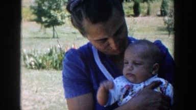1958: mother holding fist raising baby MICHIGAN