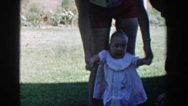 1958: baby trying to walking in the yard, with the help of mom. MICHIGAN