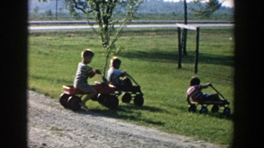 1958: little kids rolling down the hill on wagons. MICHIGAN
