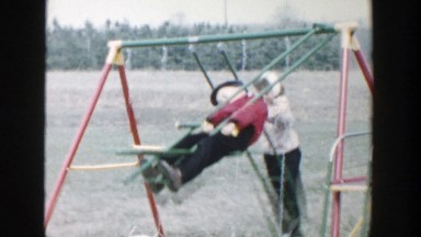 1958: boy and girl playing on swings MICHIGAN