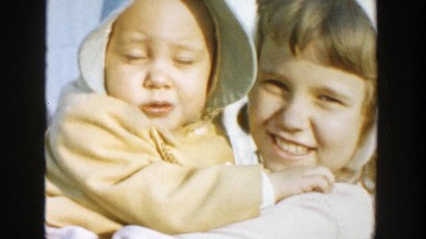 1958: child shows of her her baby sister in the yard. MICHIGAN