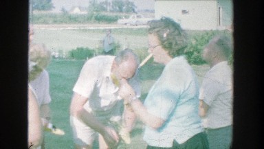 1964: group of people enjoying a day outside, eating corn. MICHIGAN