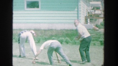 1964: family and friends gathered together playing a backyard game, enjoying