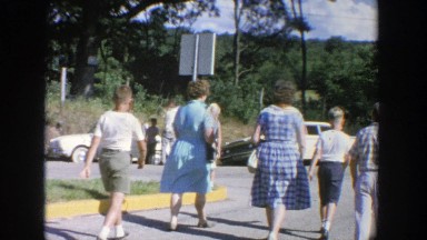 1964: family of five walking on the street towards their vehicle WISCONSIN
