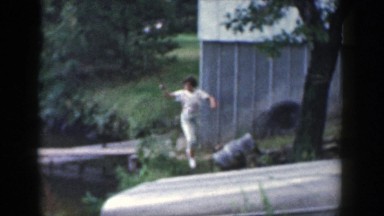 1964: Woman Walking Holding Fishing Pole on Wisconsin Dock
