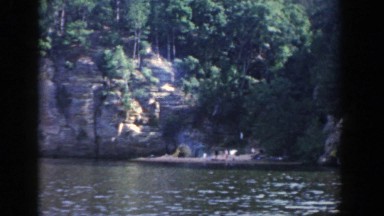 1964: people walking through the dense woods on the shore of a river WISCONSIN