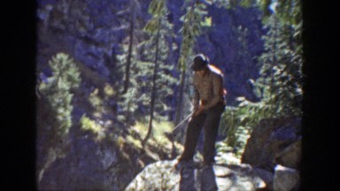 1936: man standing on a rock casting his pole. CALIFORNIA