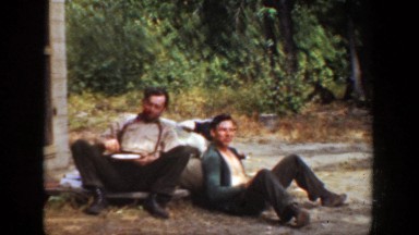 1936: two men sitting on the side of the road talking. CALIFORNIA