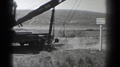 1936: an earth mover is working in a vast arid land with grasses CALIFORNIA
