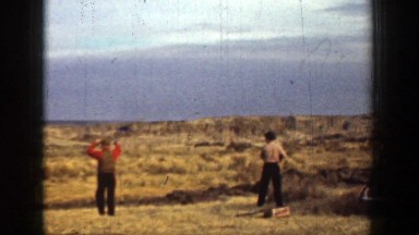 1936: three men in a rural setting practice shooting a shotgun CALIFORNIA