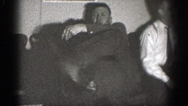 1939: two men goofing around and wrestling in a room in front of chairs CHELAN