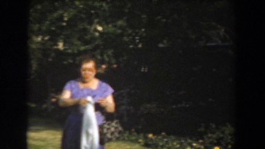 1961: an old lady with towel and bag in hands walking down LOS ANGELES