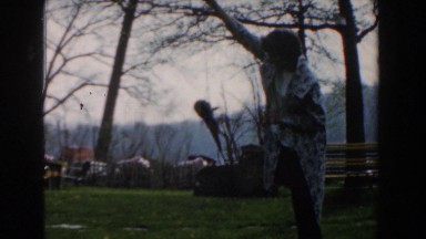 1961: a woman holding a fish on a line above the grass NOVI MICHIGAN