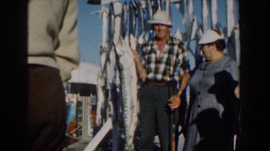 1961: Excited Fisherman and Wife Pose with Long Ocean Fish on Nassau Pier