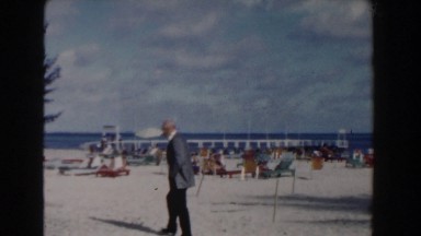 1961: Man in Suit Walking on Nassau Beach, Bahamas