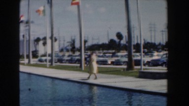1961: Woman Walking on Boardwalk Near Ocean in Nassau, Bahamas