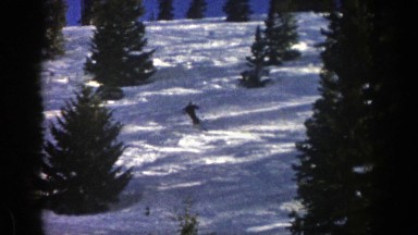 1961: Man Slalom Skiing Down Snowy Mountain with Evergreen Trees Aspen Colorado
