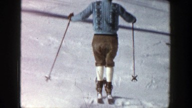 1961: a man wearing blue sweater doing ice skating down the hill ASPEN COLORADO