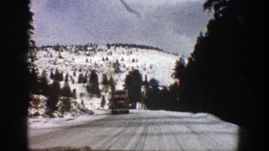 1961: Driver Heads Toward Mountain Passing Truck in Opposite Lane on Snowy Road