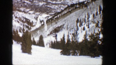 1961: skiers on a ski lift in snowy forest environment ASPEN COLORADO