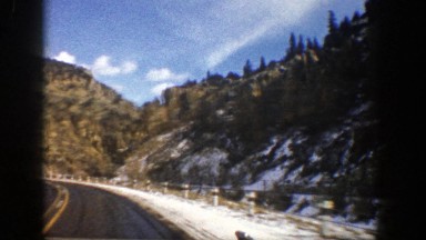 1961: cruising along a snow-lined road in the mountains ASPEN COLORADO